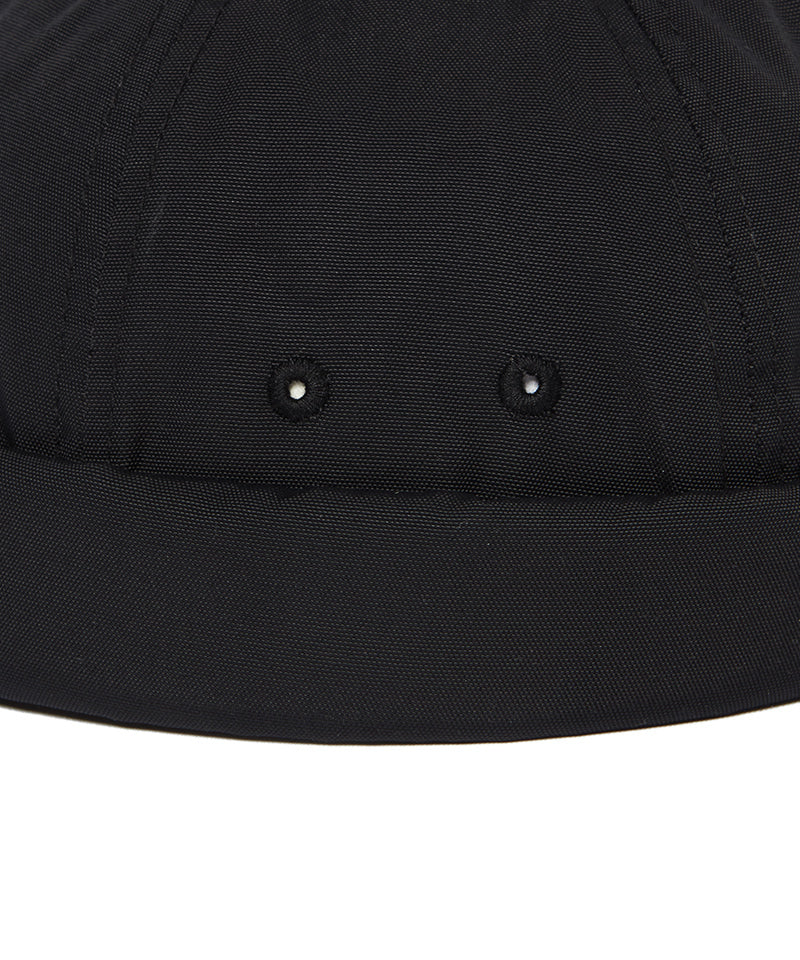 Close-up of a black cap with two buttons on a white background