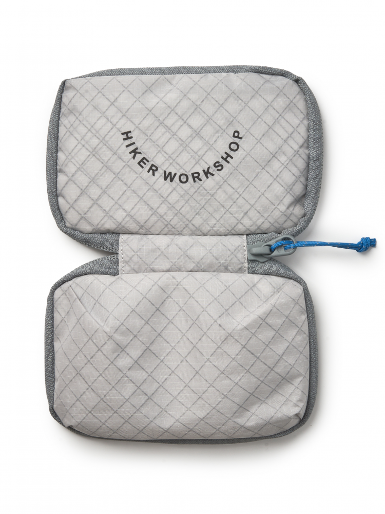 Gray quilted organizer pouch with gray zipper on, featuring Hiker Workshop logo