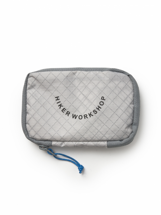 Gray quilted organizer pouch with Hiker Workshop logo.